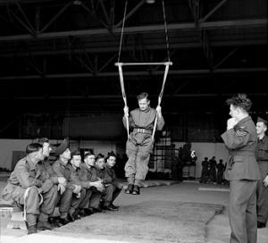 Inside a hangar, a British paratrooper learns to land correctly using a special harness, August 1942 (Imperial War Museum)