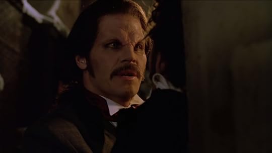 Angel is rocking an old-fashioned ponytail, a teeny little soul patch, and a mustache the size of a push broom (and just as bristly). You could brush your teeth with it, hand to God.