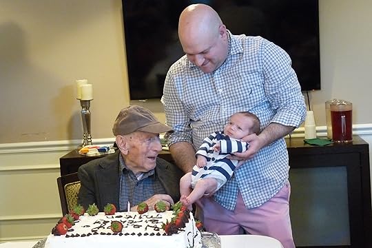 Charlie holds Caleb so that the 10 year old birthday boy and the 1-month old birthday boy can get to know each other.