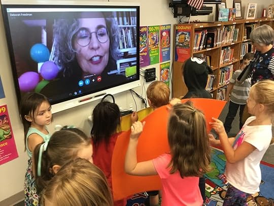 Students show me the giant book-birthday cards that they made for SHY.