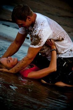 man and woman playing in the mud: 