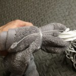 Put a the towel through the top loops of the net.