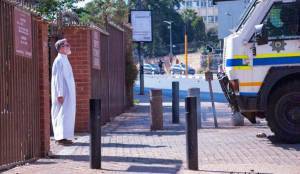 Police confront priest at entrance to church. 