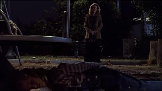 Joyce, standing horrified at the sight of a dead child on the ground, and another dead on the merry go round.
