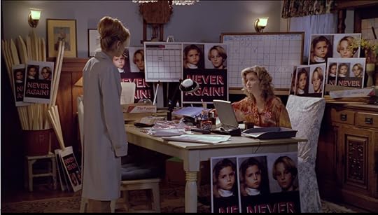 Joyce has transformed the dining room into an office full of protest signs with the dead kids' pictures on them and the words 