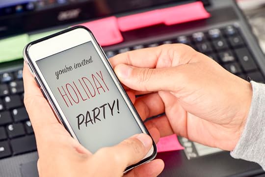 50086430 - closeup of the hands of a young man at his office holding a smartphone with the text you are invited holiday party in its screen
