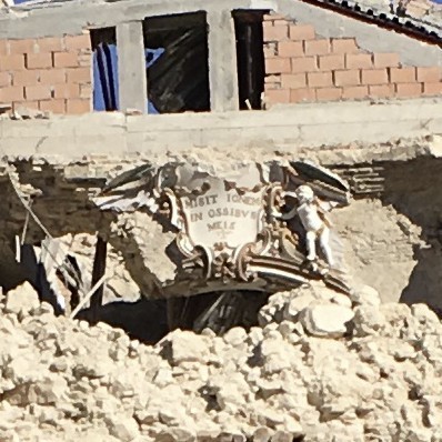 The remains of the Church of the Madonna Addolorata in Norcia. Notice the inscription over the door, still intact. It's from the Book of Lamentations. Translation from Latin: 'He hath sent fire into my bones' (Photo by the Monks of Norcia