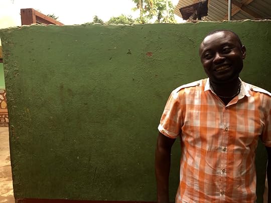 Charles Moses, 30, a new immigrant from Nigeria’s southeastern Anambra State, smiles in front of the wall of a house in Madina, a neighborhood on the outskirts of Accra that is home to many Nigerians.