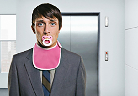 Businessman With a Pacifier and Bib --- Image by © Robin Bartholick/Corbis