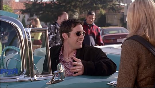 Xander is not only driving this aqua-blue and white convertible with the top down on a day where other students are wearing coats, but he's also chosen some unfortunate sunglasses and a weird paisley shirt to go with his 