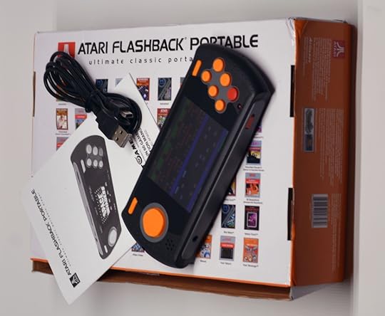 The box and its contents. Note that this is the limited pre-release review version, and the actual wide release version has a different built-in game list (e.g., no new Space Invaders port or Jungle Hunt).