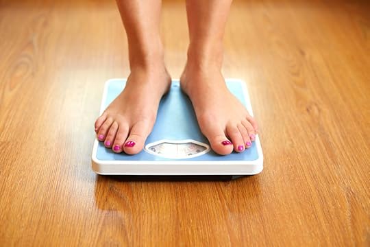 28937800 - female bare feet with weight scale on wooden floor