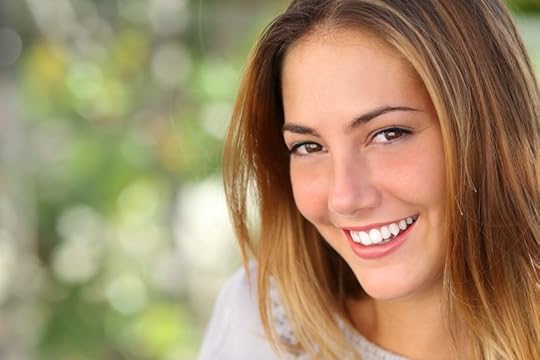 22371773 - beautiful woman with a whiten perfect smile outdoor with a green background