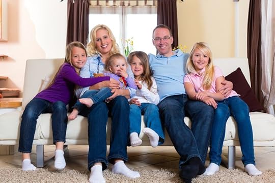 15833389 - family, father, mother and four sisters sitting on a couch in their living room