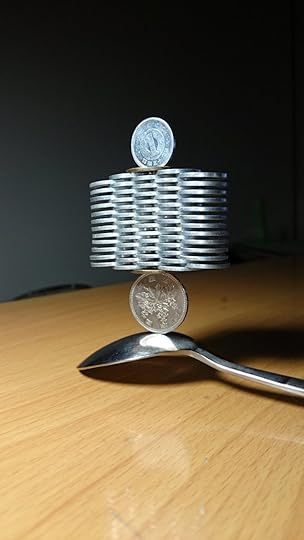 Stacked coins balanced on a spoon