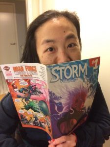 A picture of Alice Wong reading an issue of Storm comics