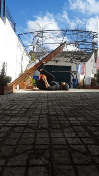 licicnois gois doing leg presses with a homemade door and water bottle set up