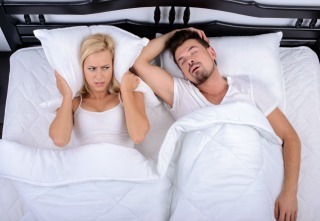 Young woman can not sleep through the snoring of her husband in her bedroom