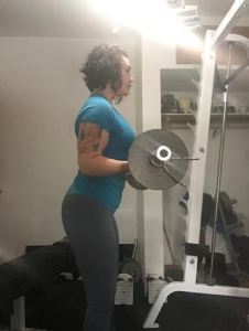tayler shrader doing curls in her home gym