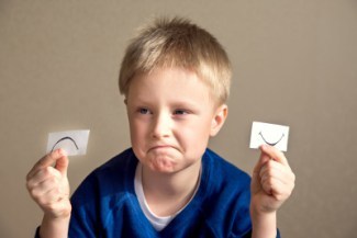 Young boy select between positive and negative expressions