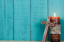 stock-photo-textured-candle-burning-and-rugged-wooden-cross-with-rope-by-antique-rustic-teal-blue-wooden-349725605