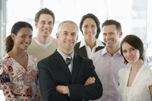Coworkers in Office surrounding smiling boss