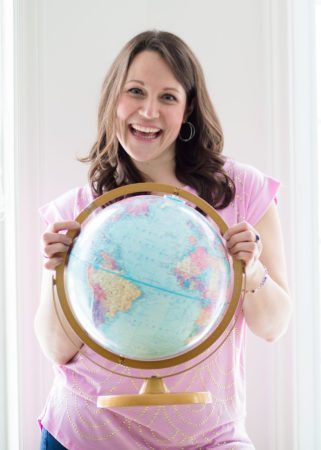Jennifer Trask Business and Mindset Coach holding a globe