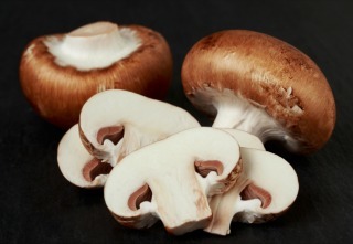 the raw royal mushrooms on a black background