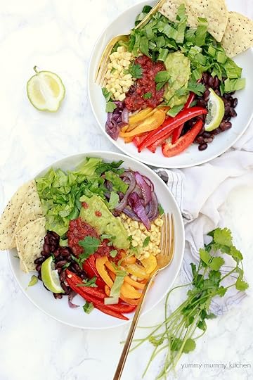 Vegan fajita bowls with quinoa, peppers, onions, and veggies and topped with guacamole and salsa.