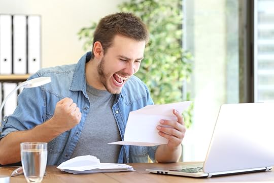 Casual excited entrepreneur reading a letter with good news in a desktop at workplace