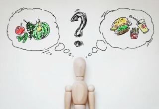 Man choosing healthy food. Abstract image with wooden puppet