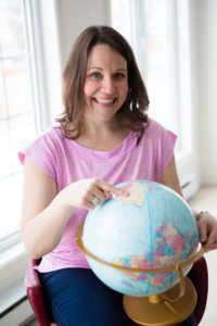 Jennifer Trask mindset coach and business advisor for coaches and healers with a globe