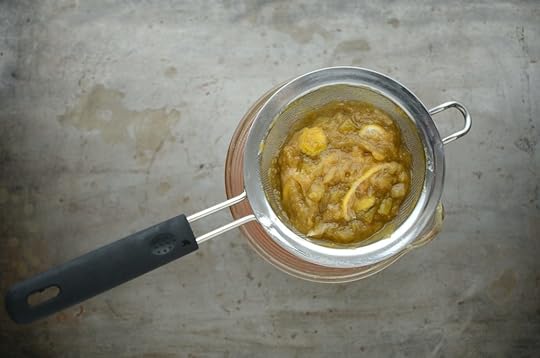 Straining cooked rhubarb for honey sweetened rhubarb meyer lemon cordial.