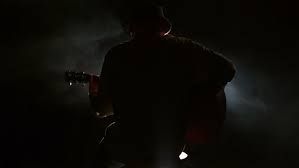 guitar player performing on a stool: 