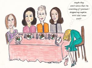 Five women sitting at a dining table, with the woman sitting at the nearest edge of the table dipping her head toward the edge as the other women talk amongst each other.