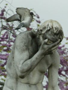 Louvre Statue of man with head in hand and a bird on his shoulder