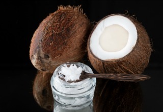 Coconut oil and coconuts on a black background