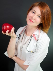 Dr. Laura Nurse Naturopathic Doctor holding an apple
