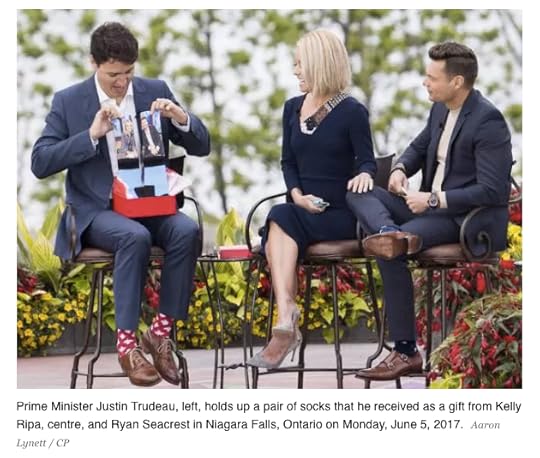 Prime Minister Justin Trudeau, left, holds up a pair of socks that he received as a gift from Kelly Ripa, centre, and Ryan Seacrest in Niagara Falls, Ontario on Monday, June 5, 2017. Aaron Lynett / CP