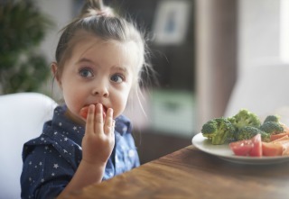 Young Child Eating Vegetables