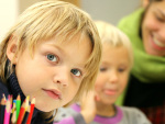 fair skinned boy with blue eyes, child and teacher in background