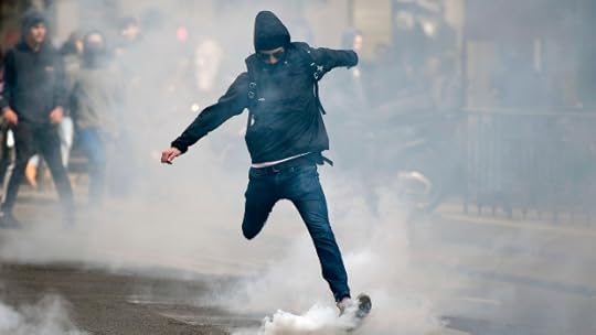 A man kicks back a tear gas canister at police in Paris on April 27, 2017 during a demonstration against the results of the first round of the presidential election.