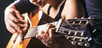 man playing guitar with a woman