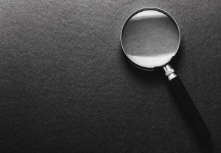 magnifying glass on black texture background.