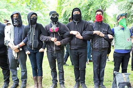 'Antifa' protesters link arms as they demonstrate at a rally