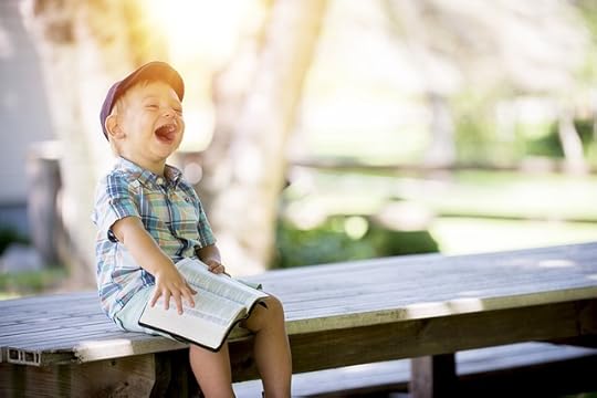 An image of a kid with a Bible on his lap, laughing. This image is in honor of the rather bad pun at the end of our second psalm.