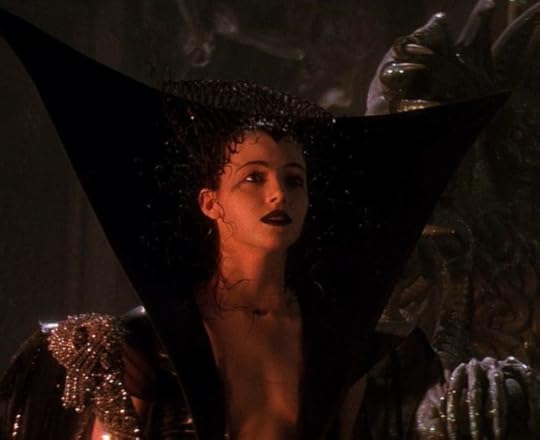 Mia Sara in Legend, wearing her Dark Lily costume. It's black, with a really tall collar that goes way up above her head like the back of a chair or something. The neckline is super low, and her makeup is all dark and dramatic.