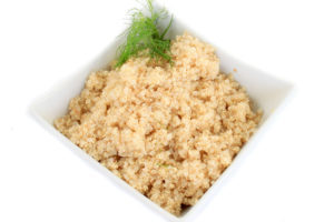 Close up on bowl of cooked quinoa grain on white background