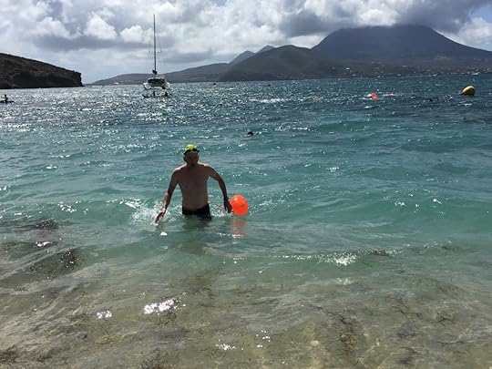 Jim Nostrum comes ashore on St. Kitts after swimming from Nevis in the background.