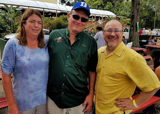Image may contain: 3 people, people smiling, people standing and outdoor